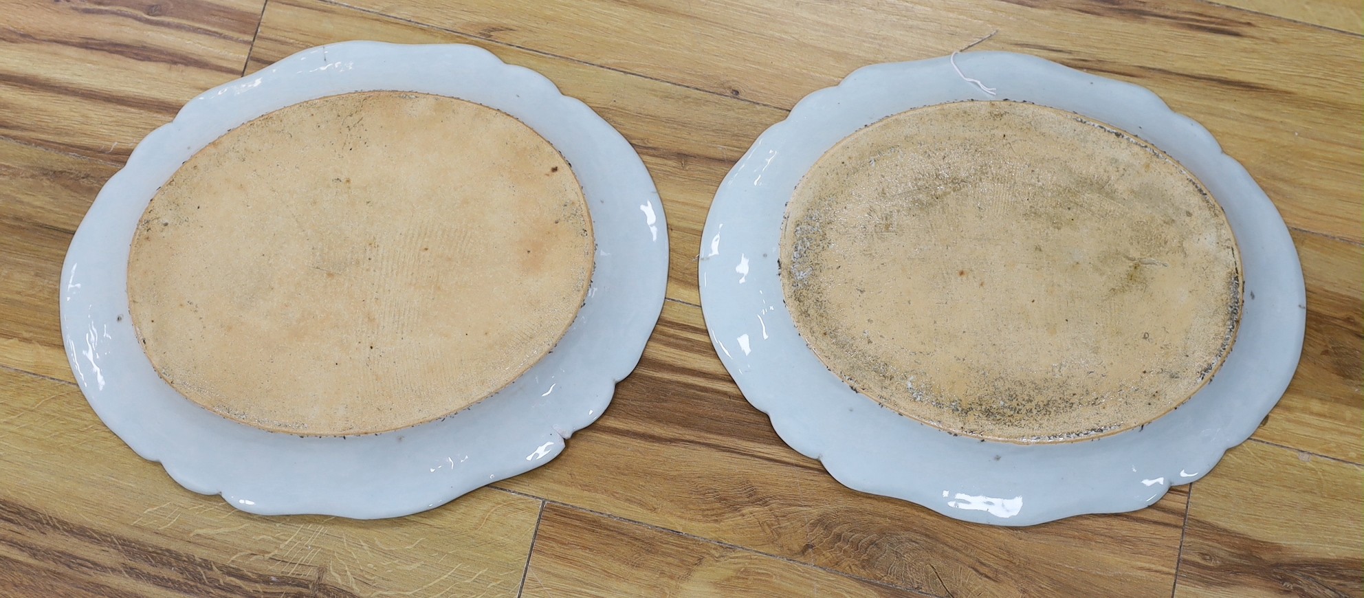 A pair of Chinese Famille Rose ‘peacock’ oval dishes, Qianlong period, 43cms wide